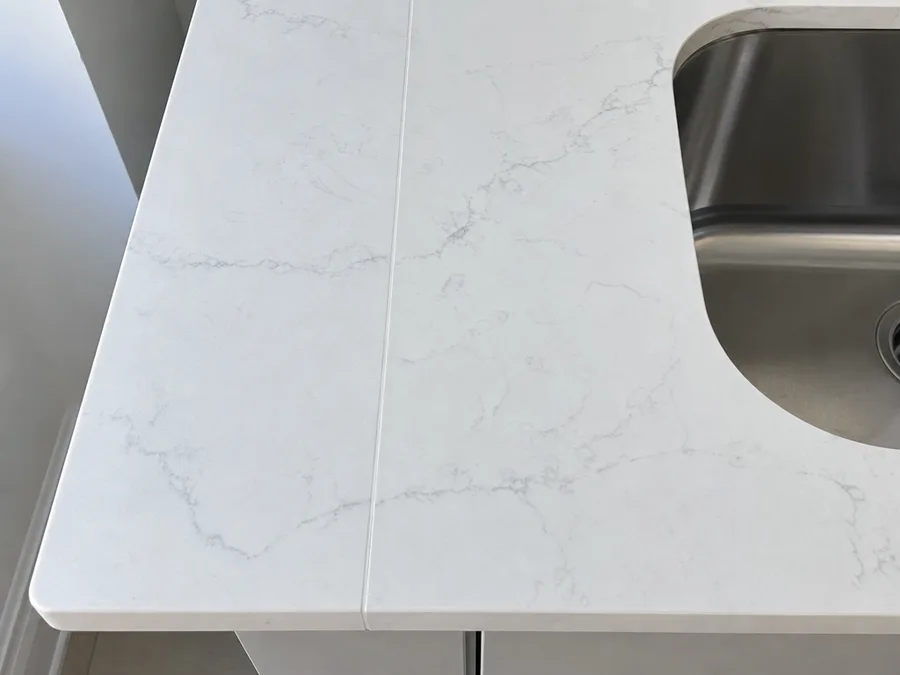 Close view of a quartz countertop corner with an eased edge and an undermount sink cut-out