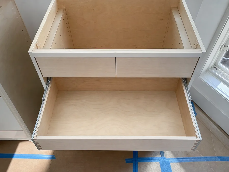 A new dovetailed drawer box on soft-close runners in an unfinished new base cabinet